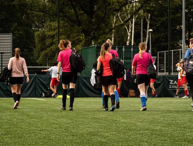 vrouwen lopen over voetbalveld